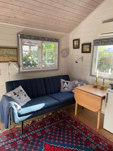 a living room with a blue couch and a table at Skagen hytte in Skagen