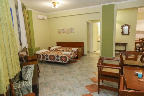 a bedroom with two beds and a table and chairs at Heaven Apartments in Agia Marina Nea Kydonias