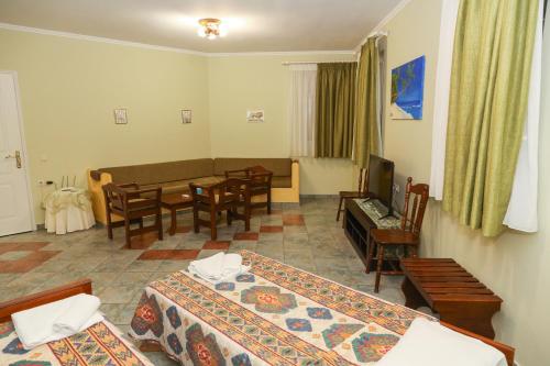 a hotel room with two beds and a dining room at Heaven Apartments in Agia Marina Nea Kydonias