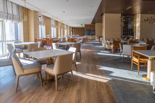 Un comedor con mesas y sillas en un restaurante. en Ethiopian Skylight Hotel, en Addis Ababa