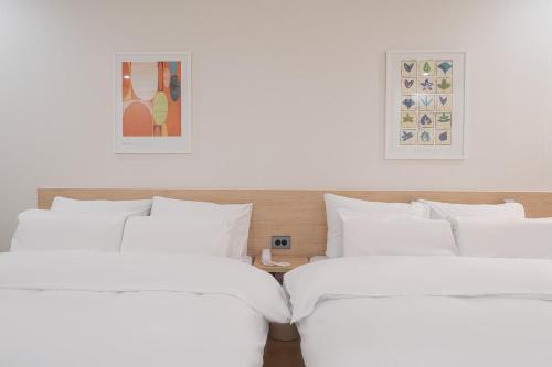 two beds sitting next to each other in a room at Aank Hotel Cheonan Station 2nd in Cheonan