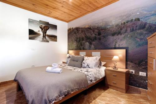 1 dormitorio con 1 cama y una pintura en la pared en Vv El Alpendre, en Moya