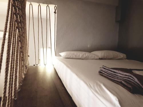 uma cama com lençóis brancos num quarto com uma janela em Loft house 2 em Ormos Panagias