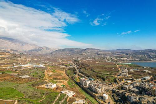 an aerial view of a city with a lake and mountains at Goland Hotel in Mas'ade