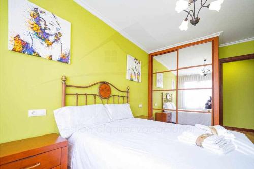 ein Schlafzimmer mit einem weißen Bett und einem Fenster in der Unterkunft El Rocio Apartamento in Gijón