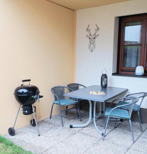 a table and chairs and a grill in a room at Apartment Gerlitzen Garden in Treffen