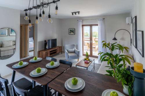 a dining room and living room with a table and chairs at Syra Bay in Megas Yialos-Nites