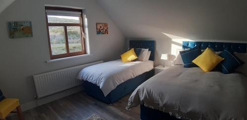 a bedroom with two beds and a window at Cherry blossom. In Erris 