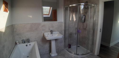 a bathroom with a shower and a sink and a tub at Cherry blossom. In Erris 