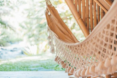 a hammock hanging from a porch swing at Hideout Eco Bamboo House Bali in Selat