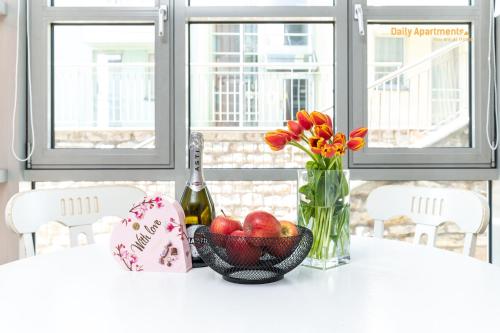 a table with a bowl of fruit and a vase of flowers at Luxury Suites - Noblessner with Sauna in Tallinn