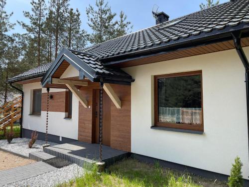una pequeña casa con techo negro en Agroturystyka Dom turystyczny Chomiczówka, en Płaska