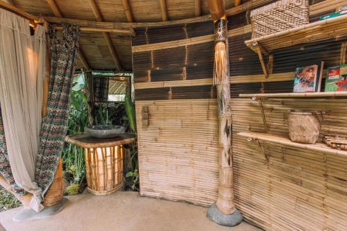 an outside view of a room with a wooden wall at Hideout Eco Bamboo House Bali in Selat