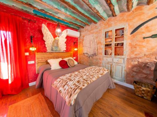 1 dormitorio con 1 cama en una habitación con paredes rojas en Domus Lapidis - Ibera en Bogarra