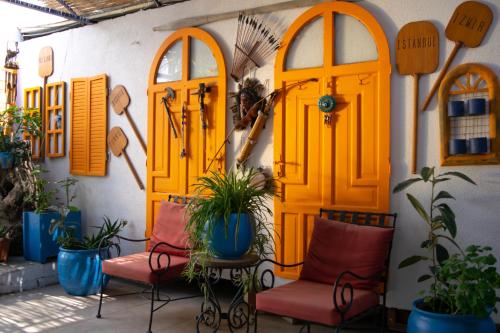 a patio with orange doors and chairs and plants at Akkan Beach Hotel in Bodrum City