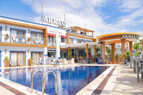 a hotel with a swimming pool in front of a building at Akkan Beach Hotel in Bodrum City