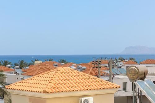a view of the roofs of buildings and the ocean at Heaven Apartments in Agia Marina Nea Kydonias
