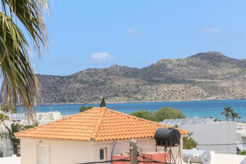a building with an orange roof with a view of the water at Heaven Apartments in Agia Marina Nea Kydonias