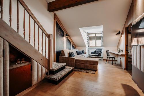 a living room with a staircase and a couch at Der Eisvogel - Wellness- & Genusshotel in Bad Gögging