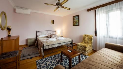 ein Schlafzimmer mit einem Bett, einem Stuhl und einem Sofa in der Unterkunft Fani's House Under Meteora in Kastraki