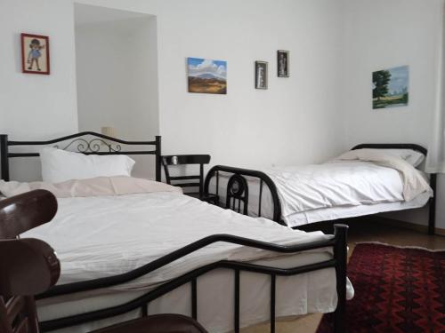 two twin beds in a room with white walls at Traditional House "Elisavet" in Próti