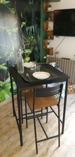 une table noire et une chaise avec une assiette dessus dans l'établissement Le jardin d'Eden, à Troarn
