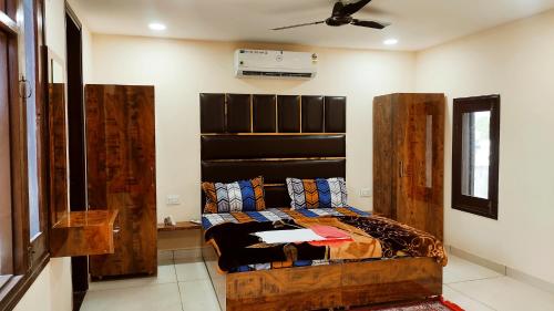 a bedroom with a wooden bed in a room at THE RAJMANI MOTEL -- LUXURY STUDIO ROOMS -- LPU Law Gate in Phagwāra