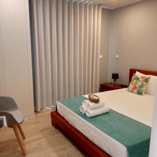 a bedroom with a bed with two towels on it at Ancoradouro T1 - Alojamento Local Gerês in Braga