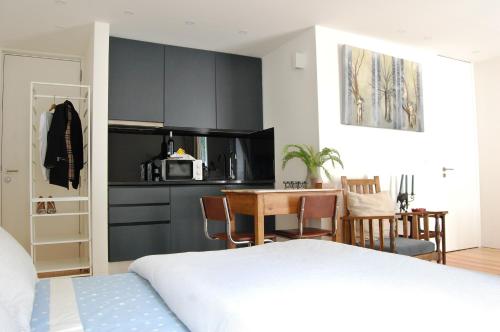 Cet appartement comprend une chambre avec un lit et une table ainsi qu'une cuisine. dans l'établissement Serralves 1108 -Estudio 0, à Porto