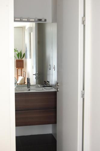 La salle de bains est pourvue d'un lavabo et d'un miroir. dans l'établissement Serralves 1108 -Estudio 0, à Porto