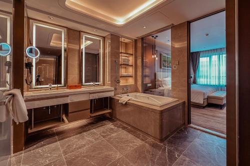 un baño con bañera y lavabo en Ethiopian Skylight Hotel, en Addis Ababa