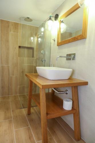 a bathroom with a white sink and a shower at Heaven Apartments in Agia Marina Nea Kydonias