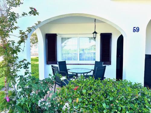 a patio with a table and chairs and a window at Ca Mestral Son Bou Urbanización típica menorquina. in Son Bou