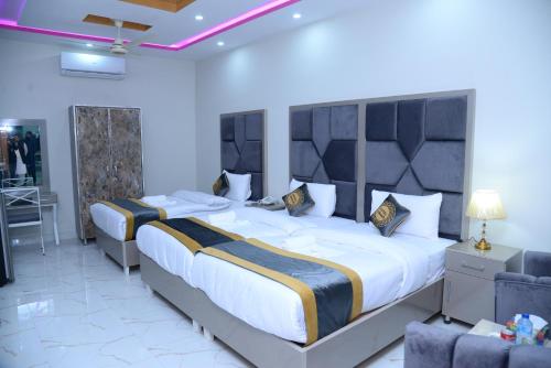 GO Luxury Grand Hotel في لاهور: غرفة نوم كبيرة بسريرين وطاولة