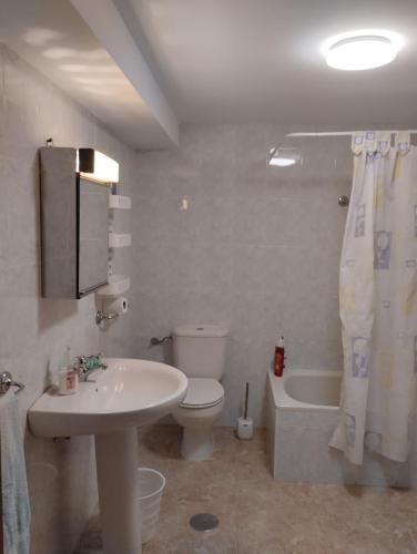 a bathroom with a sink and a toilet and a tub at Casa Fuentefria in Ourense