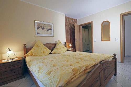 ein Schlafzimmer mit einem großen Bett mit gelber Decke in der Unterkunft Ferienwohnung Villa Waldesruh in Saarburg