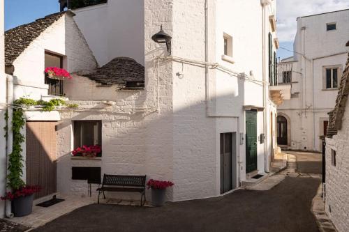 a bench sitting outside of a white building at Il Trullo Moore Alberobello in Alberobello