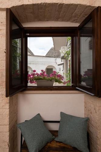 two pillows sitting on a bench in front of a window at Il Trullo Moore Alberobello in Alberobello
