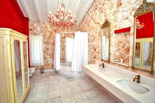 a large bathroom with two sinks and two mirrors at Villa Helios Corfu Kassiopi in Kassiopi