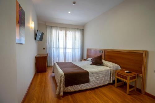 ein Hotelzimmer mit einem Bett und einem Fenster in der Unterkunft Hotel Los Barruecos in Malpartida de Cáceres