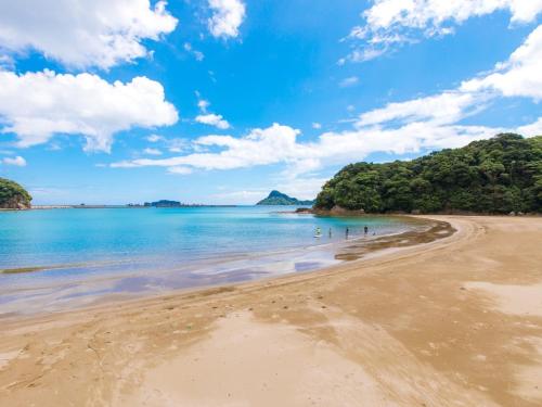 a group of people walking on the beach at Nichinankaigan Nango Prince Hotel in Nichinan