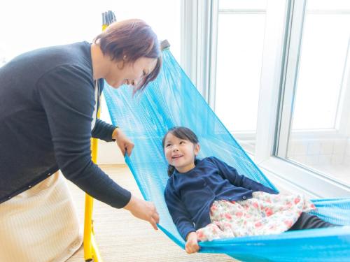 a woman playing with a little girl in a hammock at Nichinankaigan Nango Prince Hotel in Nichinan