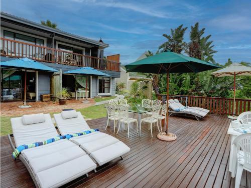a deck with white furniture and an umbrella at RiverView in Wilderness
