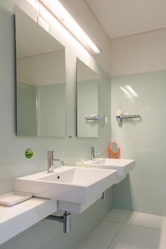 a bathroom with two sinks and a large mirror at Porto Lounge Hostel & Guesthouse by Host Wise in Porto