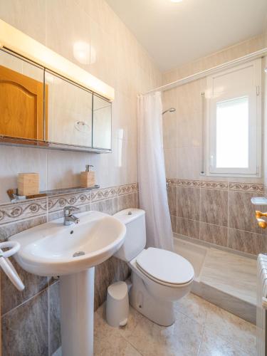 a bathroom with a toilet and a sink and a shower at Villa Mercedes in L'Escala