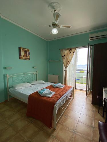 ein Schlafzimmer mit einem Bett und einem großen Fenster in der Unterkunft Panagioula in Methana