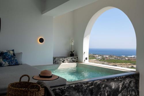 a room with a plunge pool with a hat on it at Amera Suites in Fira