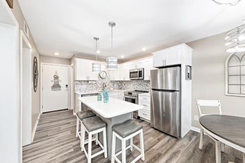 a kitchen with white cabinets and a white table and chairs at Plantation 2308 in Gulf Shores