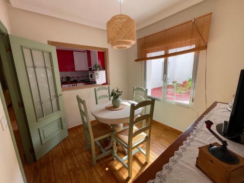 a kitchen and dining room with a table and chairs at Como una casa de campo en la ciudad, con patio -Parking gratis in Gijón