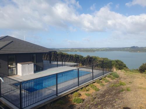 una casa con piscina en una terraza en Makuri Bay Hideaway, en Purerua